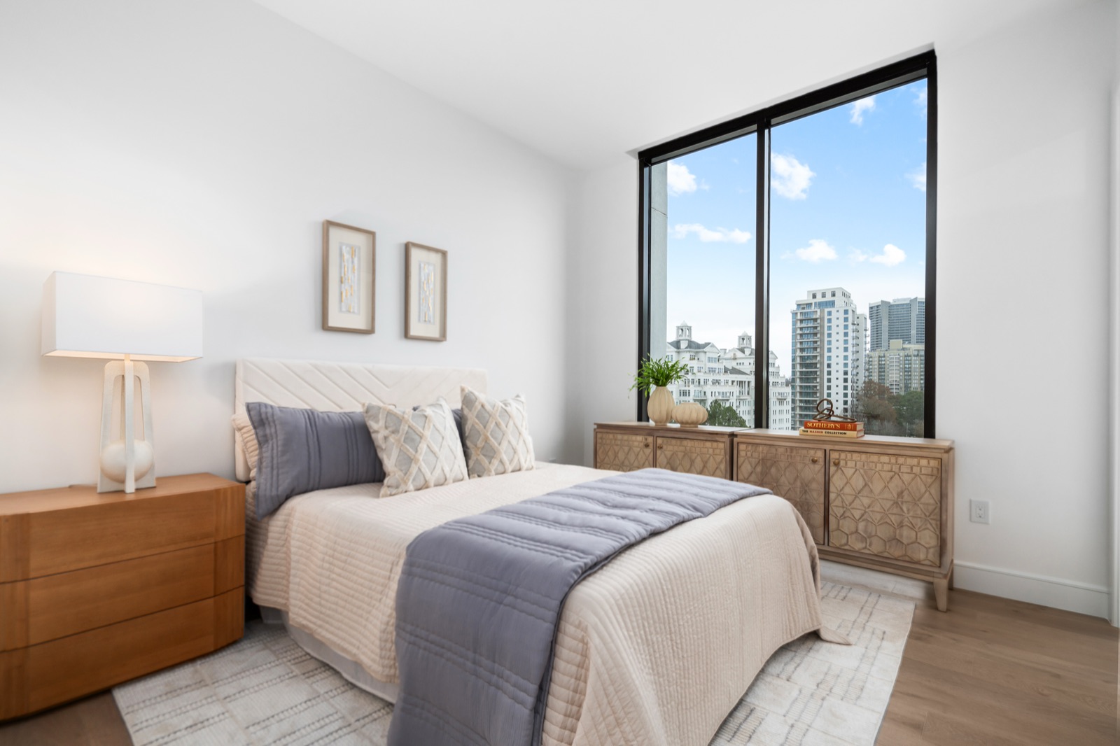 Modern bedroom with a city-view window, staged by Design2Sell